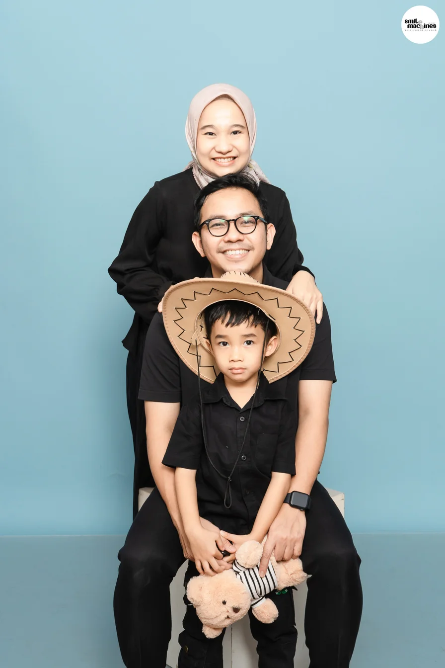 Foto keluarga dengan background biru muda.